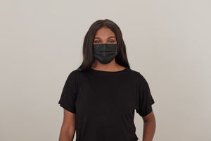 Woman wearing a black t-shirt and black mask.